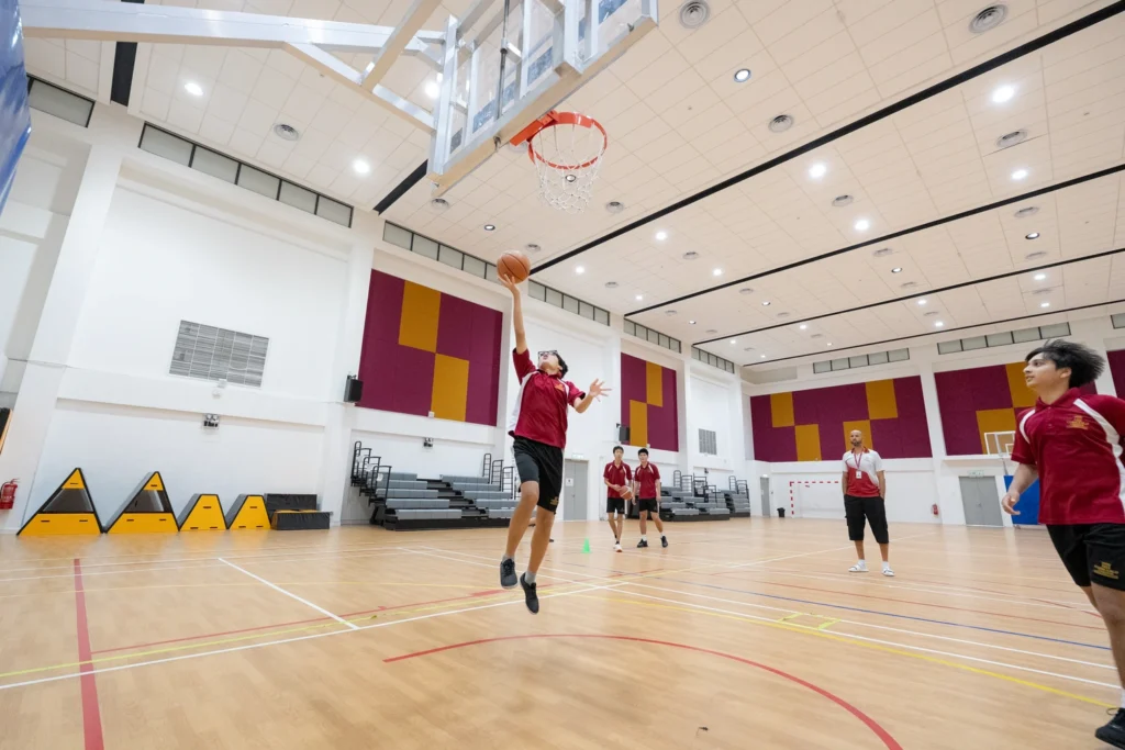 A student shoots during basketball practice.