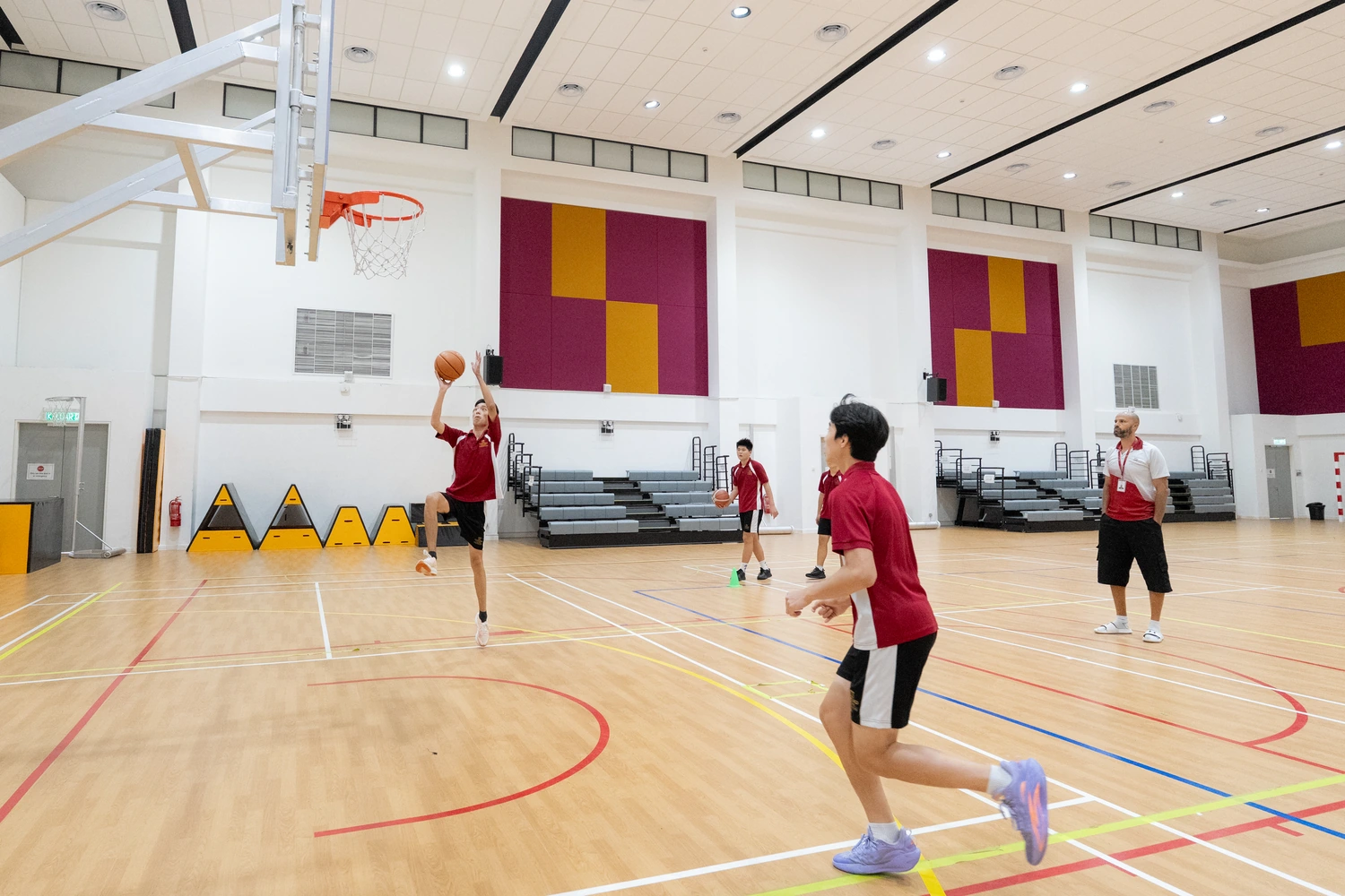 Students play basketball in the school sports hall.