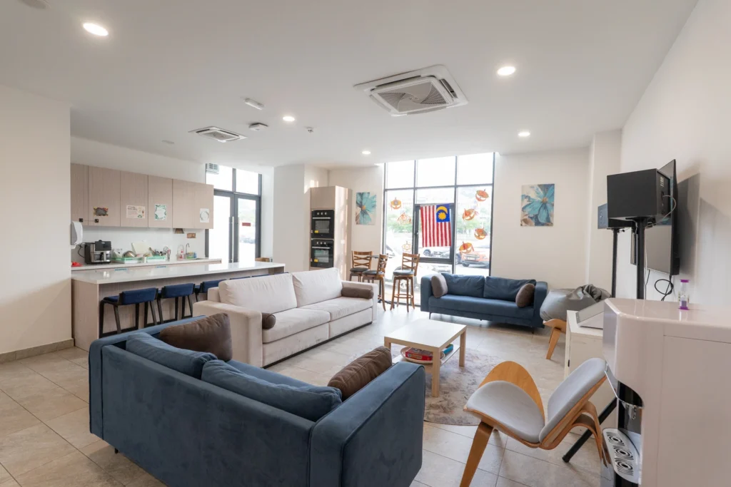 The boarding common room with sofas, a television and a kitchenette.