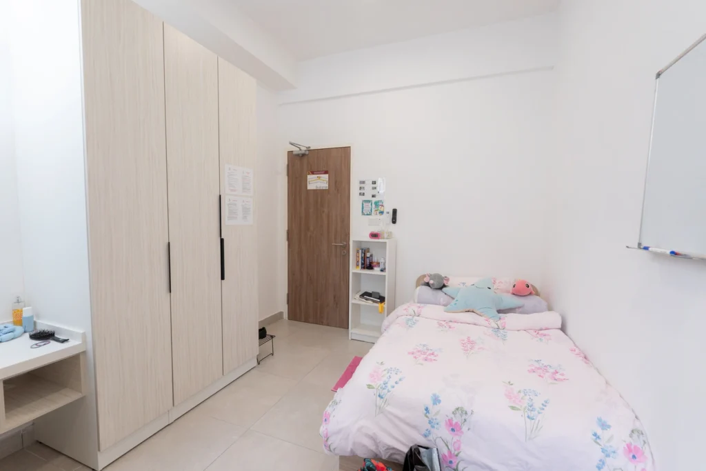A boarding room personalised with soft furnishings and a wardrobe.