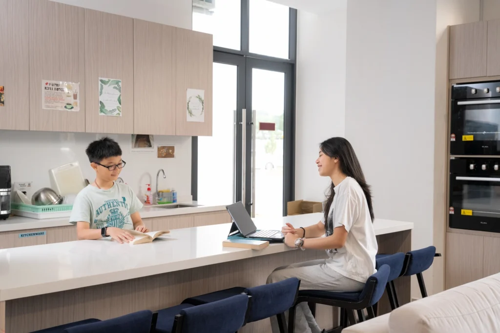 Boarders talk at the kitchen counter of the boarding house.