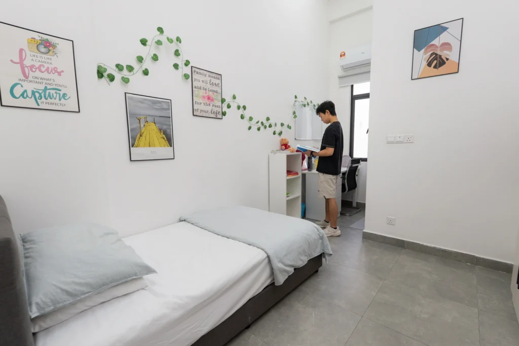 A boarder stands at the desk of their personalised boarding room.