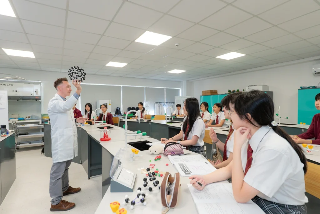 A chemistry teacher demonstrates to a full laboratory class.