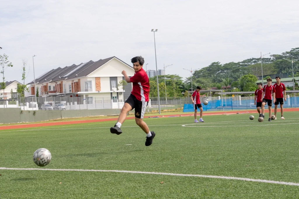 A student shoots at goal during football training.