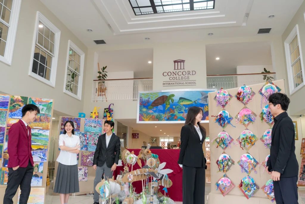Students talk in the school foyer beneath the Concord College sign.