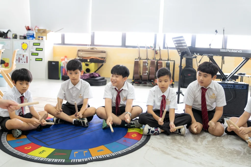 Students play rhythm sticks together in the music room.