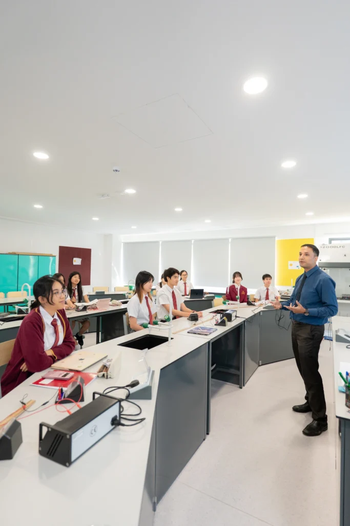 A physics teacher works with his class in the laboratory.