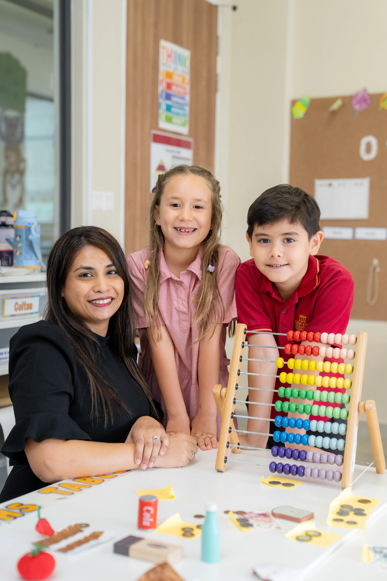 A teacher and two Year 1 students counting together on a large abacus.