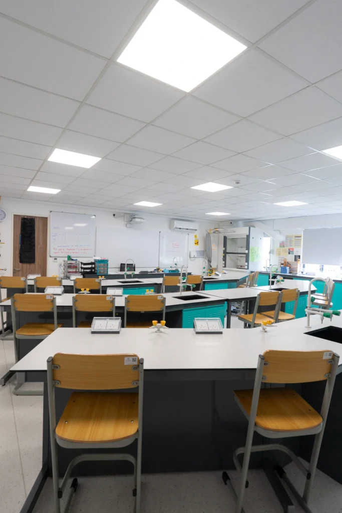 A chemistry laboratory with high benches and stools arranged for practical work.