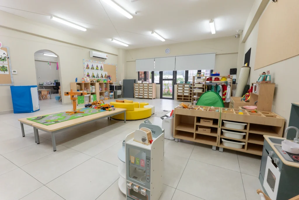 An Early Years classroom with low furniture, play equipment and activity areas.