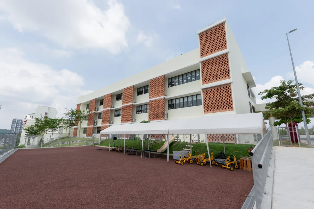 The Early Years playground with play equipment beside the school building.