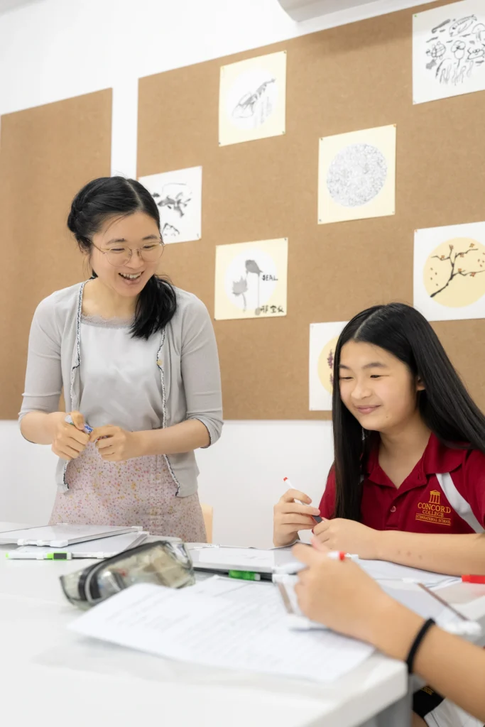 A teacher works one to one with a student during a Mandarin lesson.