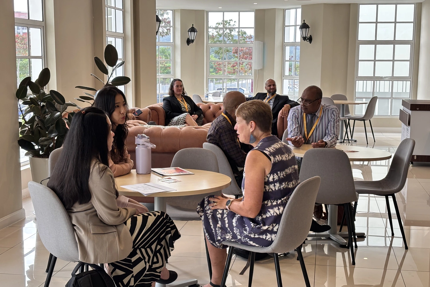 Colleagues talking together around a table in the school cafe.