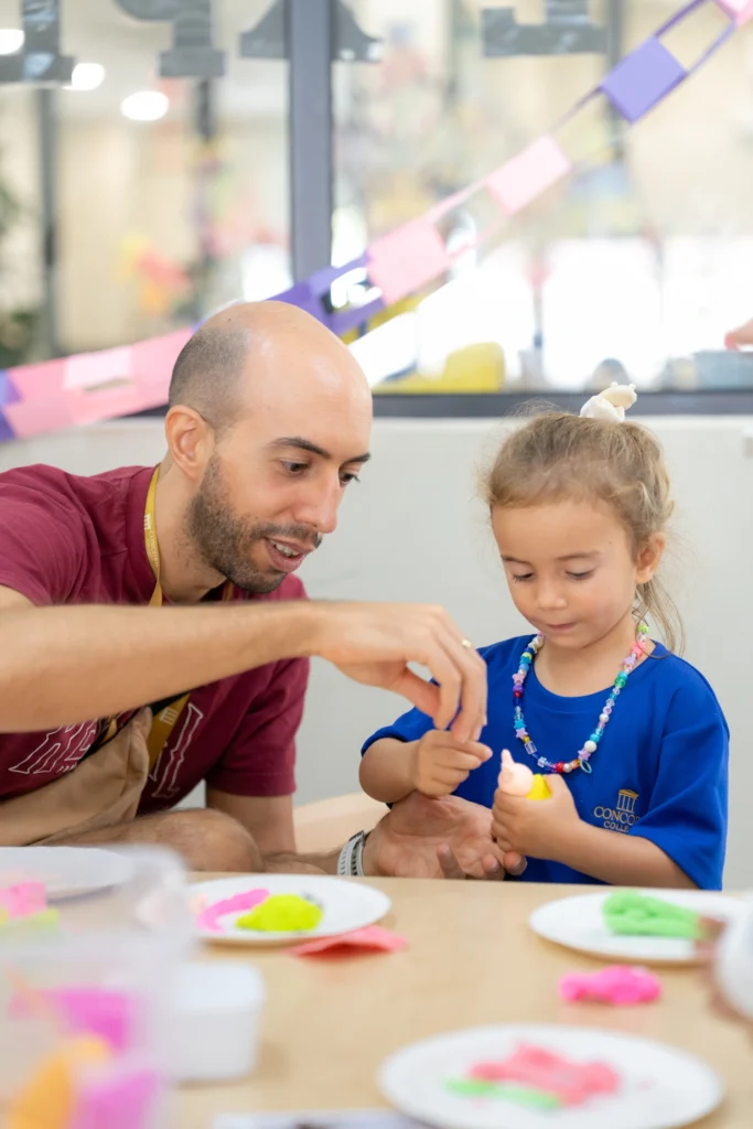 A father and his young daughter working together on a modelling activity during a family session at Concord College International School.
