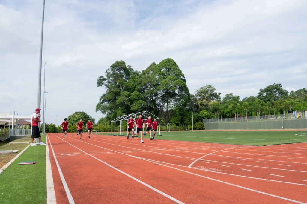 Students running on the outdoor athletics track.